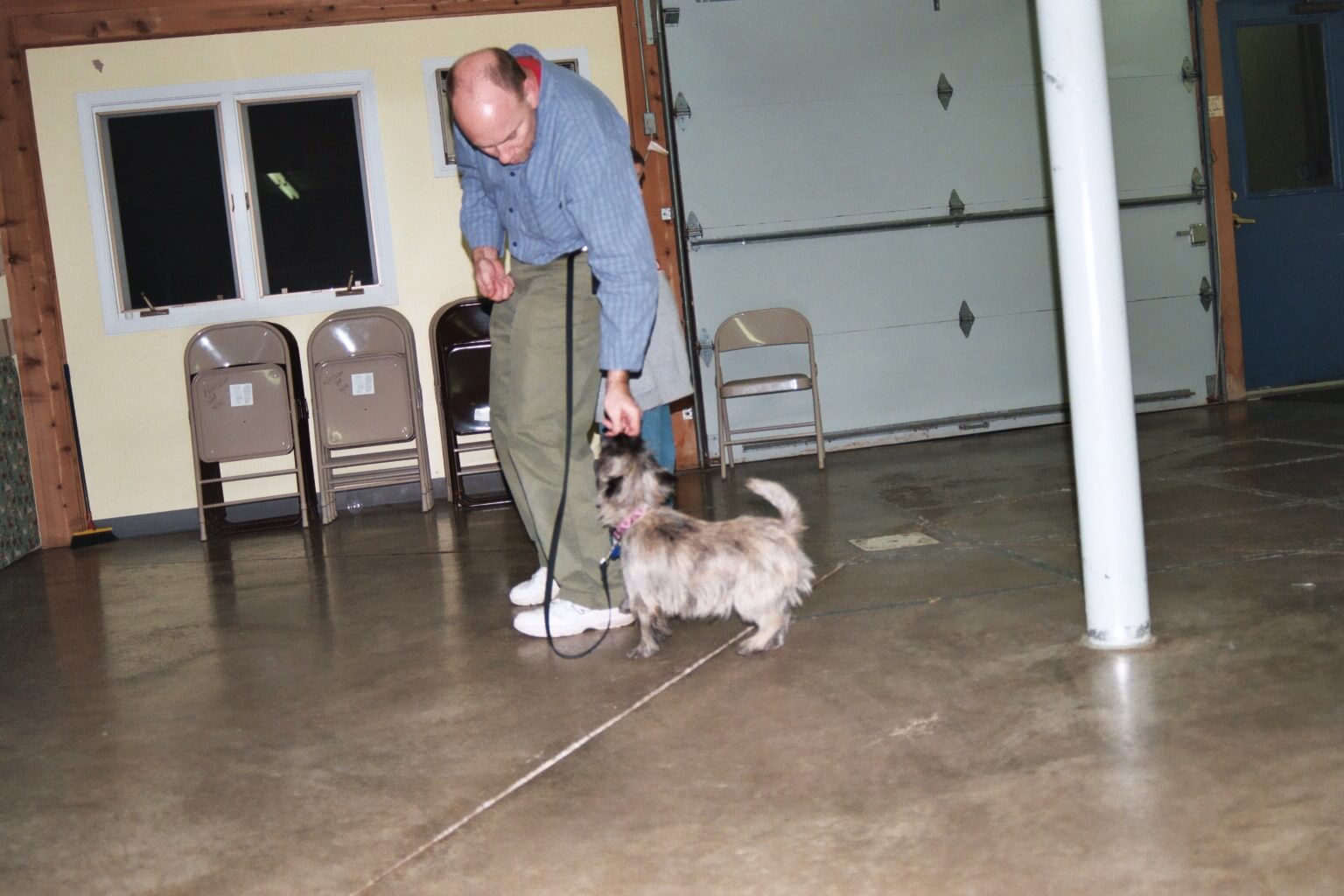 Man walking a scruffy little dog